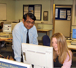 Photo of a tutor helping a student on a computer