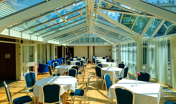 Conservatory with round tables shown, in the sunshine