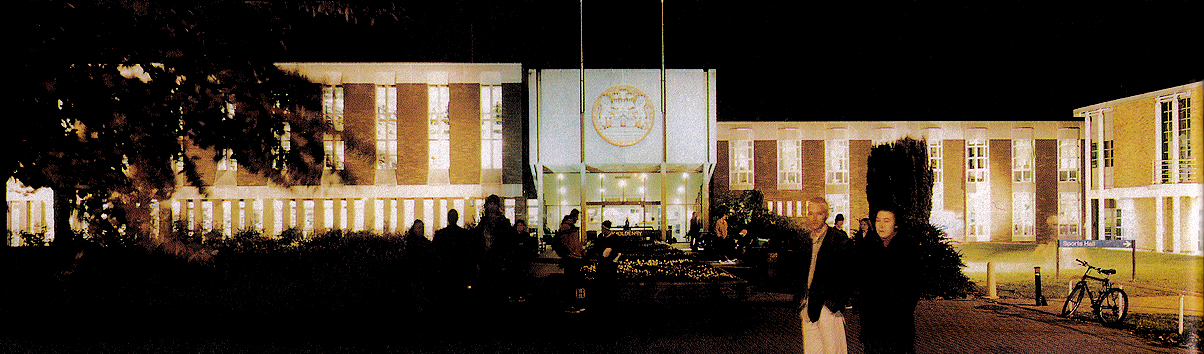 Main Building / Holdenby illuminated at night, with students present