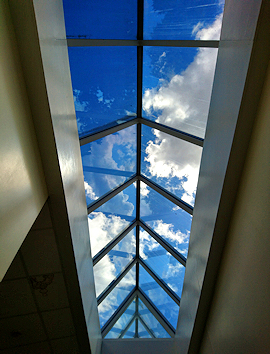 Triangular roof skylight windows with blue sky and clouds